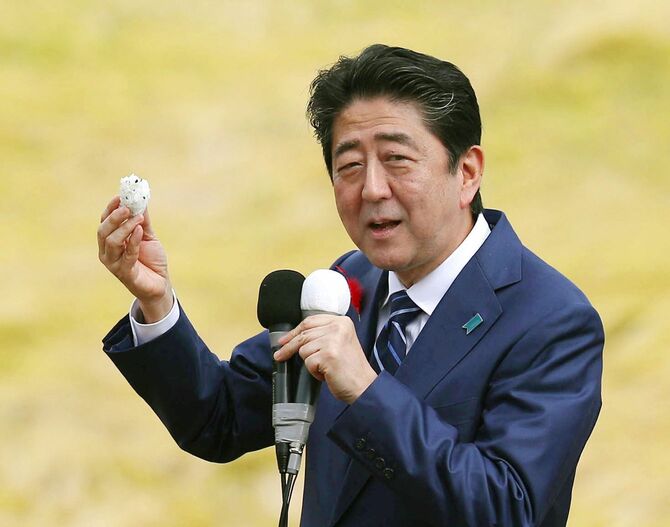 衆院選の応援演説でおにぎりを試食する安倍首相＝2017年10月、福島市