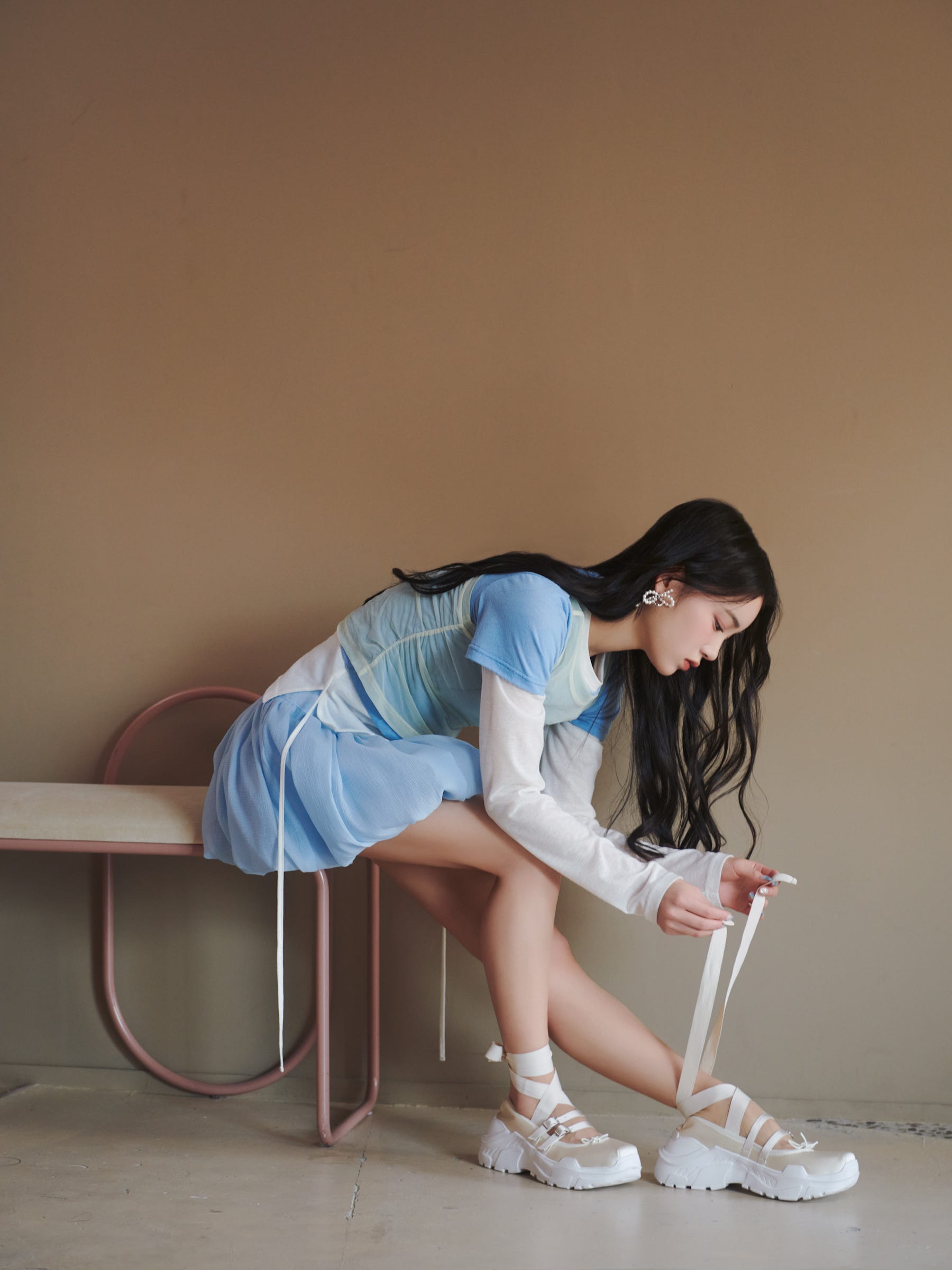 a person seated on a bench adjusting footwear