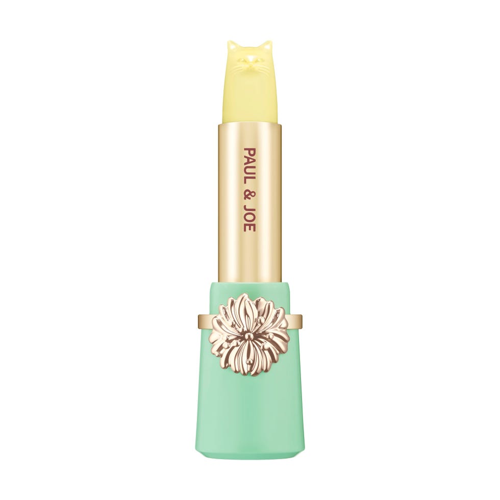 lipstick designed by paul joe featuring a catshaped cap and floral embellishment