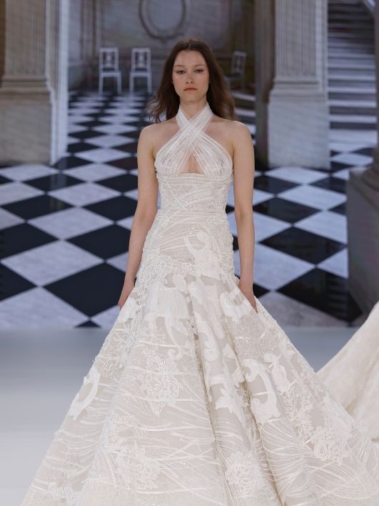 Image may contain Amber Atherton Clothing Dress Fashion Formal Wear Gown Wedding Wedding Gown Chair and Furniture