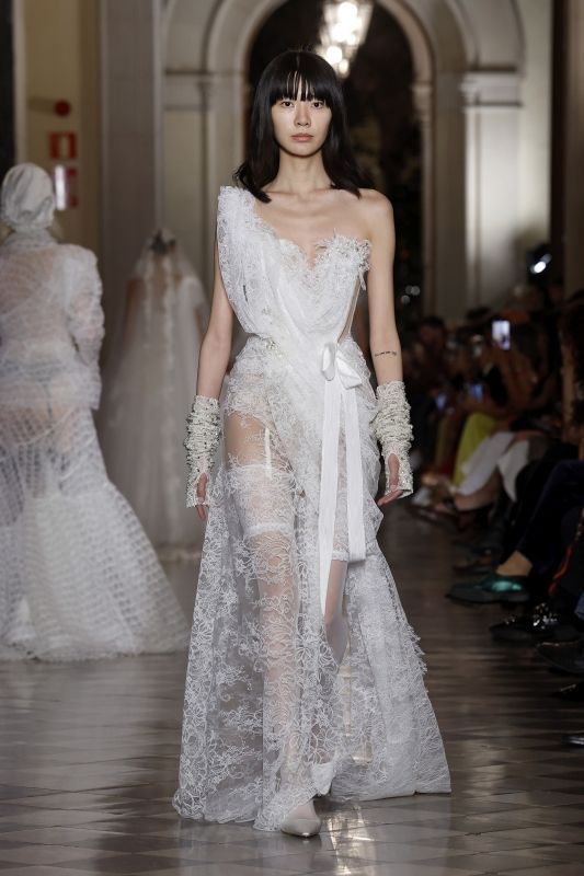 Image may contain Clothing Dress Fashion Formal Wear Gown Wedding Wedding Gown Footwear Shoe Adult and Person