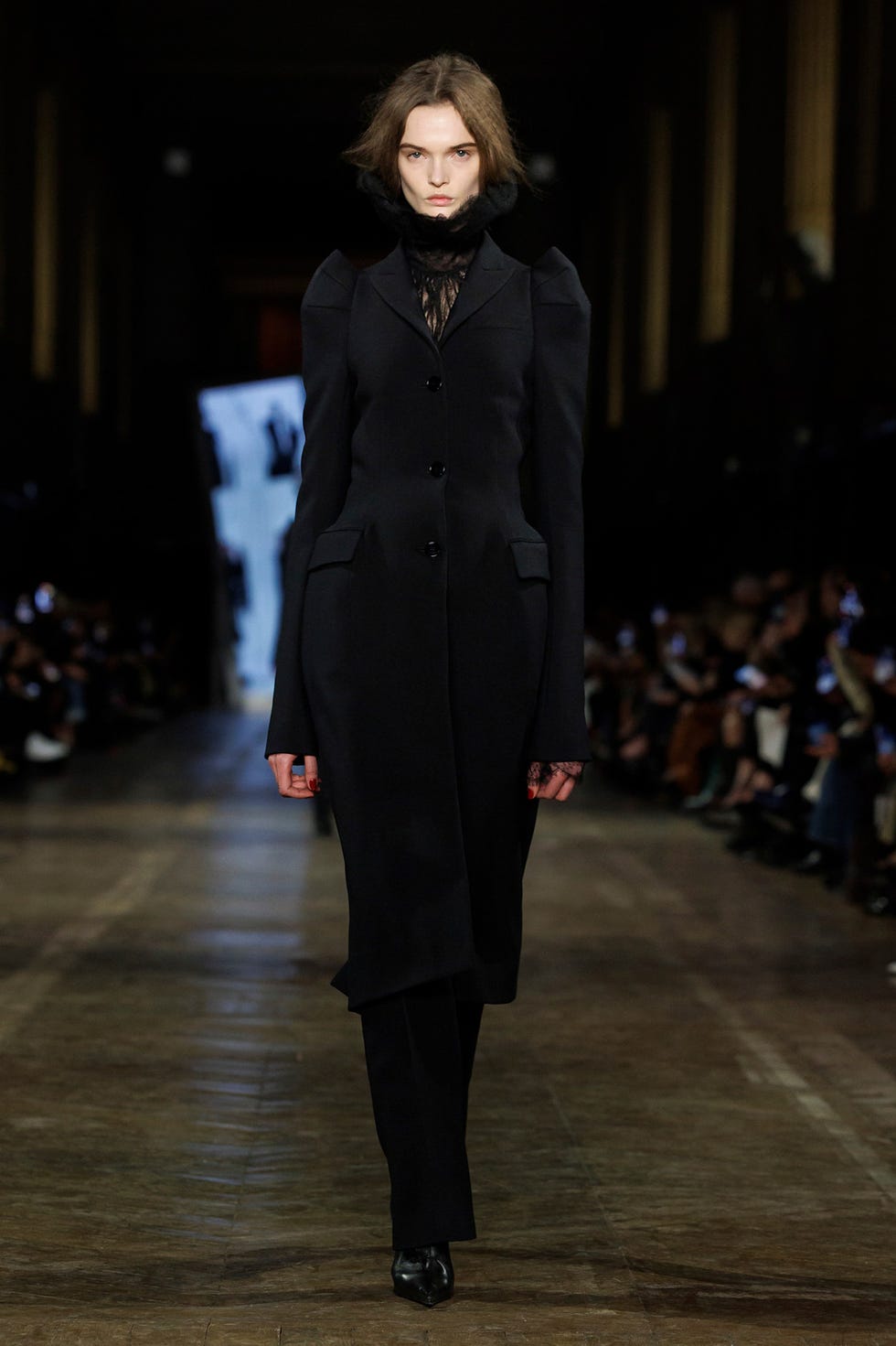 Runway model showcasing a dark tailored outfit