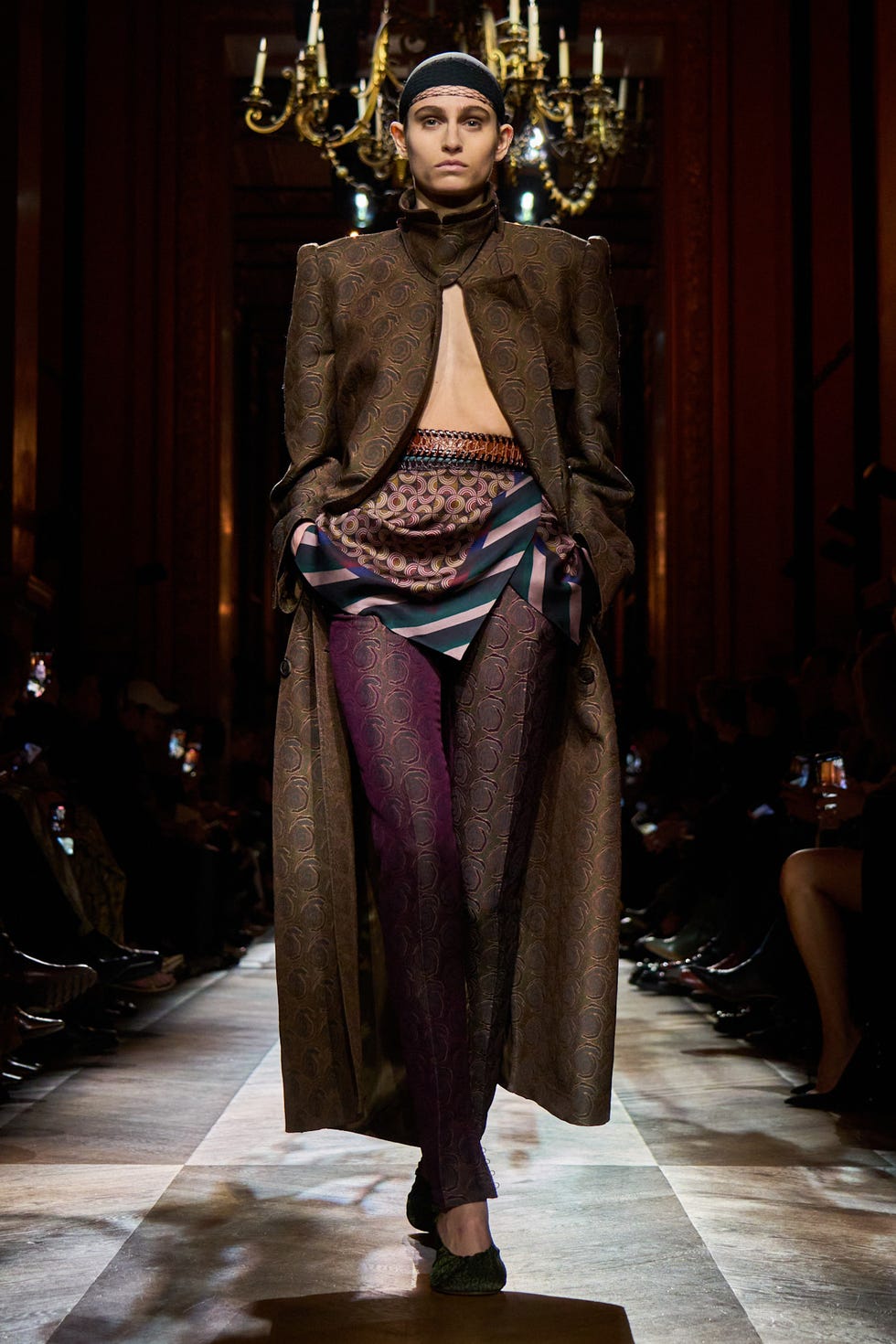 Fashion show featuring a model in a dramatic outfit