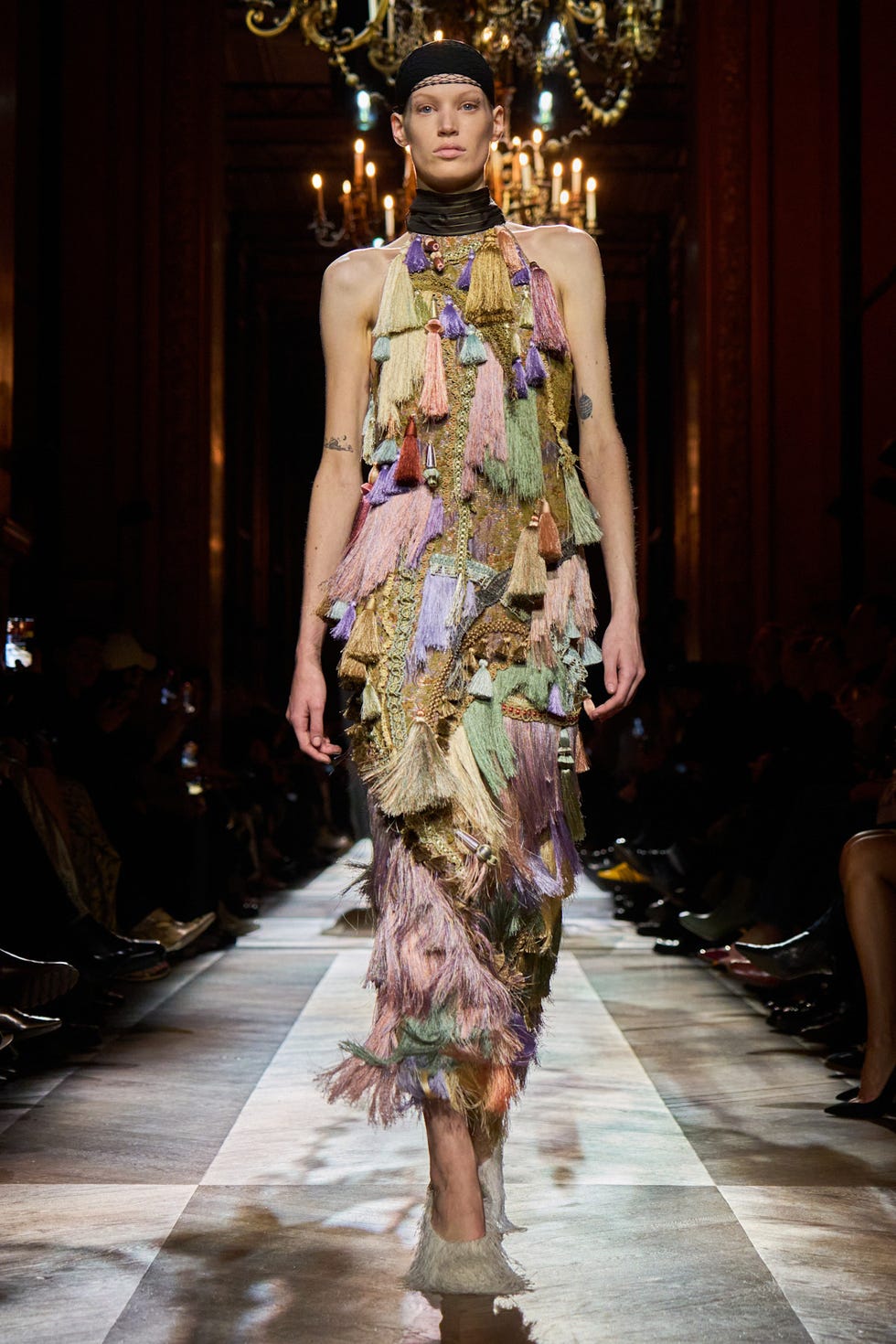 Fashion model showcasing an elaborate colorful dress on a runway