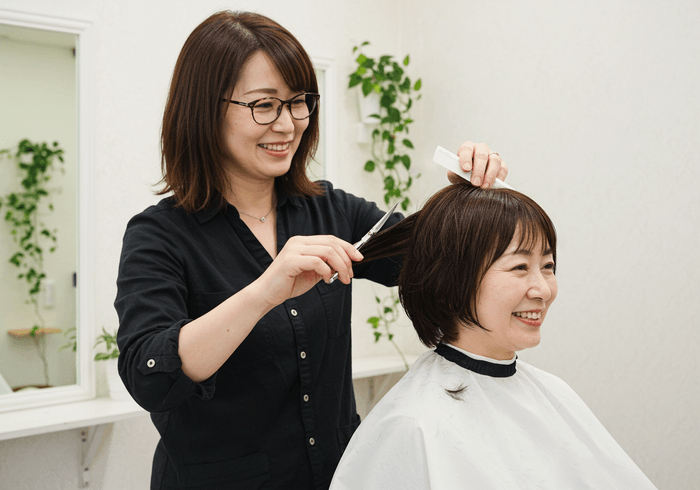 カット中の写真　アイリストとして活躍をしながら、スタイリストを目指せる