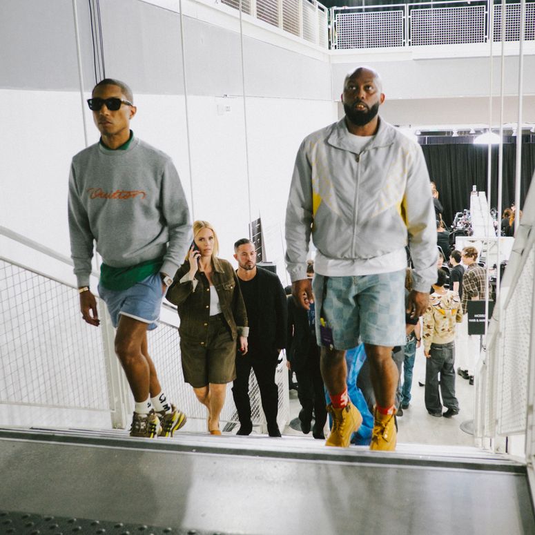 Image may contain: Pharrell Williams, Gena Lee Nolin, Clothing, Shorts, People, Person, Walking, Accessories, and Glasses
