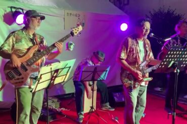 「チャンピオン」2025年8月2日土曜日、足立区青井兵和通り商店街イベントにて。アマチュアバンドSTURM（映像奥より兵頭秀一、タッチー、パラ塚、ドクター）