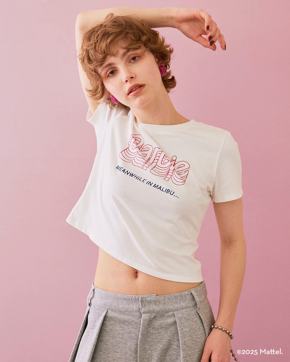 a person wearing a cropped tshirt with a pink background