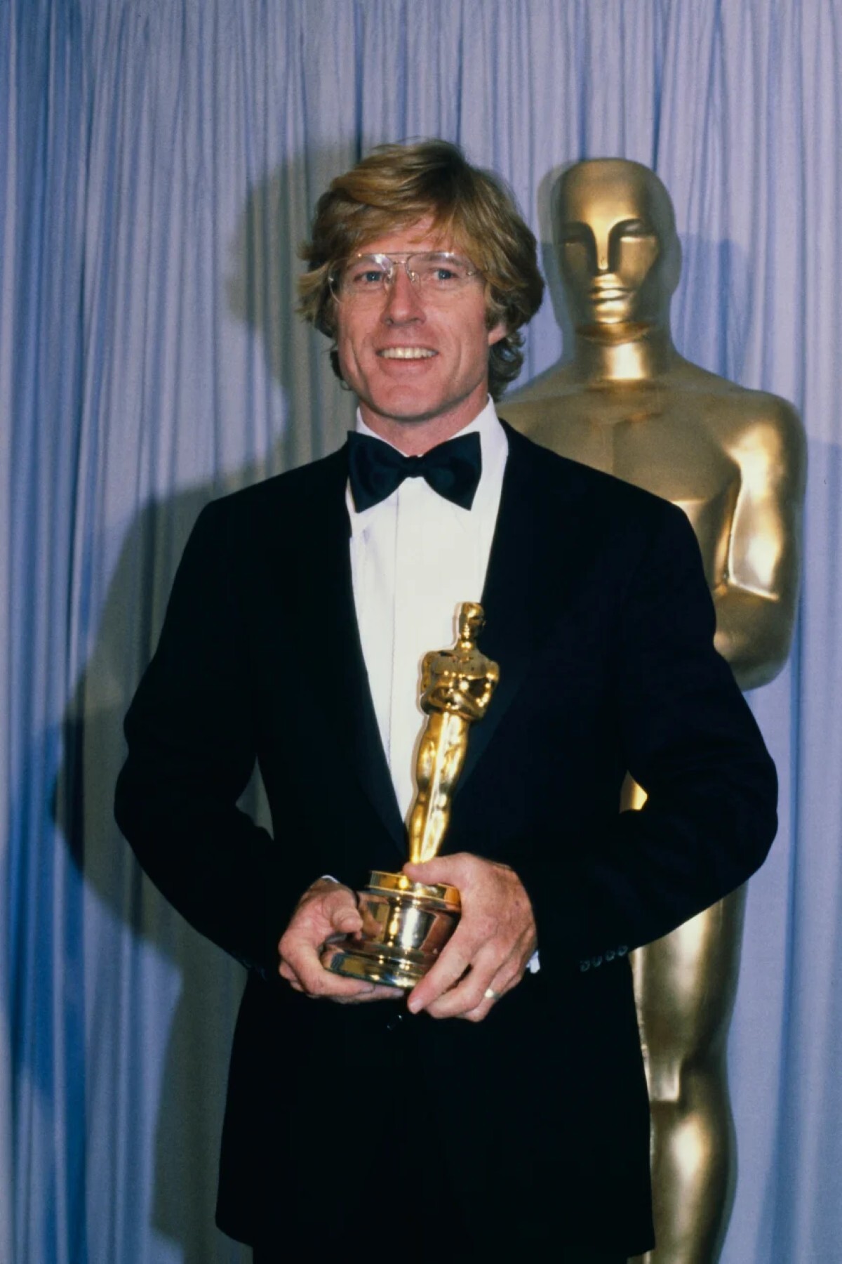 １９８１年、監督デビュー作「普通の人々」でアカデミー監督賞と作品賞を受賞した後の様子。レッドフォードさんはアビエータータイプの読書用眼鏡とクラシックな黒のタキシードを身につけた/UPI/Bettmann Archive/Getty Images