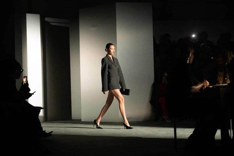 fashion model walks down the runway wearing a tailored suit
