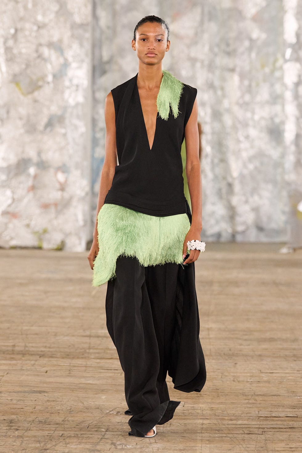 a model walks the runway showcasing a distinctive fashion design