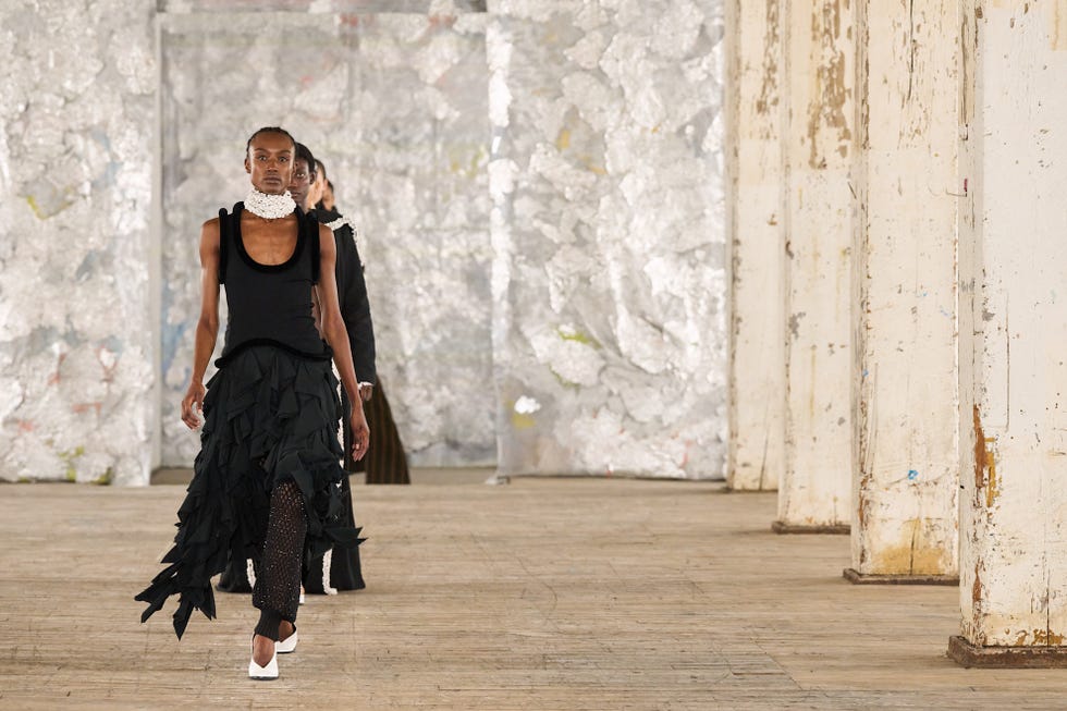 fashion models walking on a runway in a minimalist setting