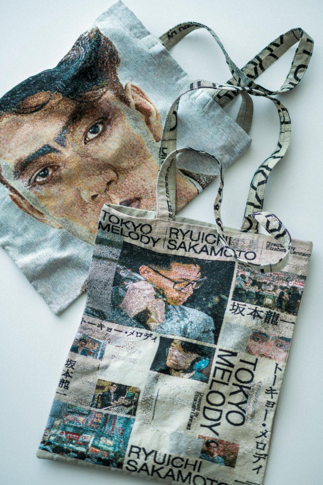 トートバッグ(フェイスデザイン) 15,400円、トートバッグ(メインポスターデザイン) 15,400円※公式オンラインストア、期間限定ストアで販売