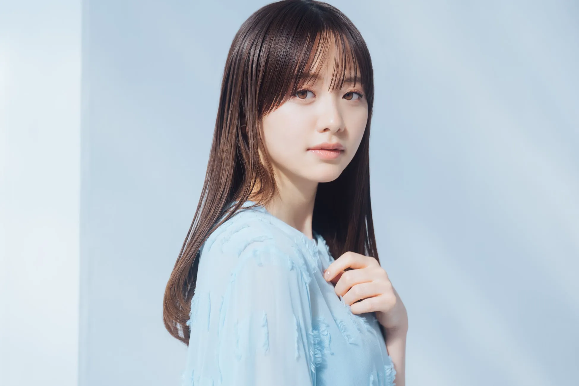 森香澄が魅せる【可憐&クール】な新境地!SNIDEL BEAUTY特設ページ「Soft Glow, Sharp Gaze」本日公開でファン必見! 9 女性のポートレート写真。彼女は長い茶色の髪をしており、薄い青色の服を着ています。彼女はカメラを見つめており、背景は白です。