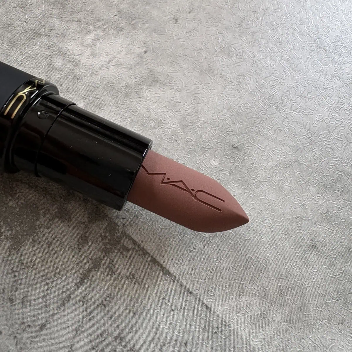 M·A·C パウダー キス ヘイジー マット リップスティック「テイケン」の先端アップ。やわらかなヌードブラウンカラー