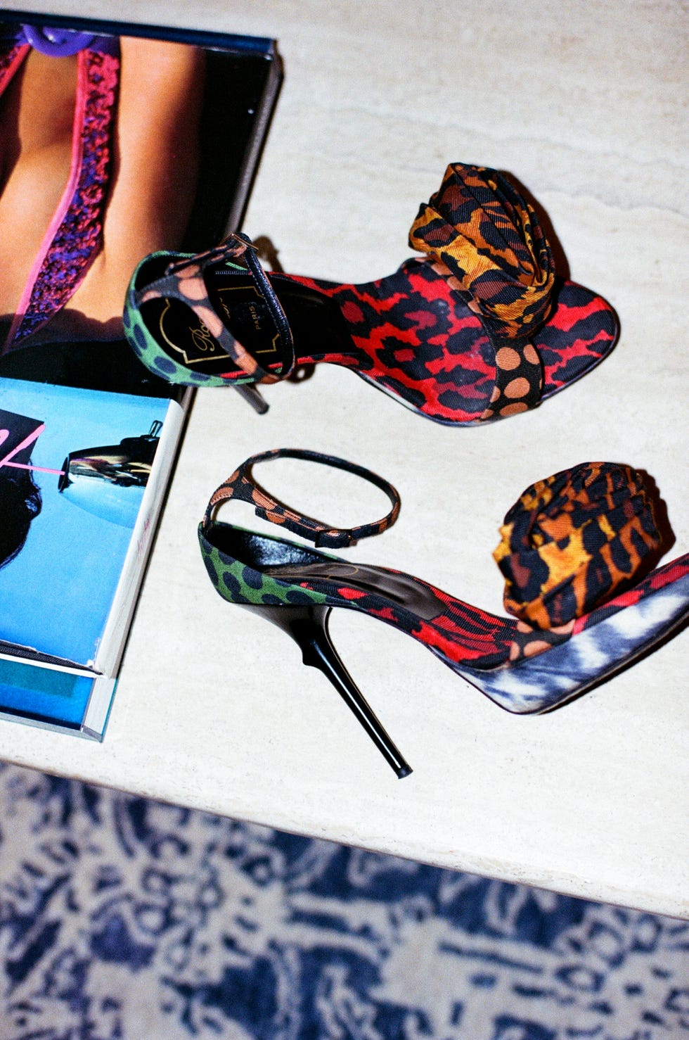 stylish highheeled shoes on a table beside a magazine