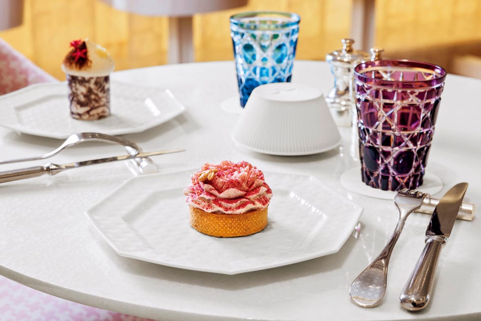 “ディオール コード”と呼ばれるブランドのアイコンが刻まれた江戸切子のグラス。デザート皿とカトラリーにも「カナージュ」柄が施される。花びら形のケーキ4,500円（手前）と、洋服と同様のプリントが施されたケーキ4,000円（奥）。