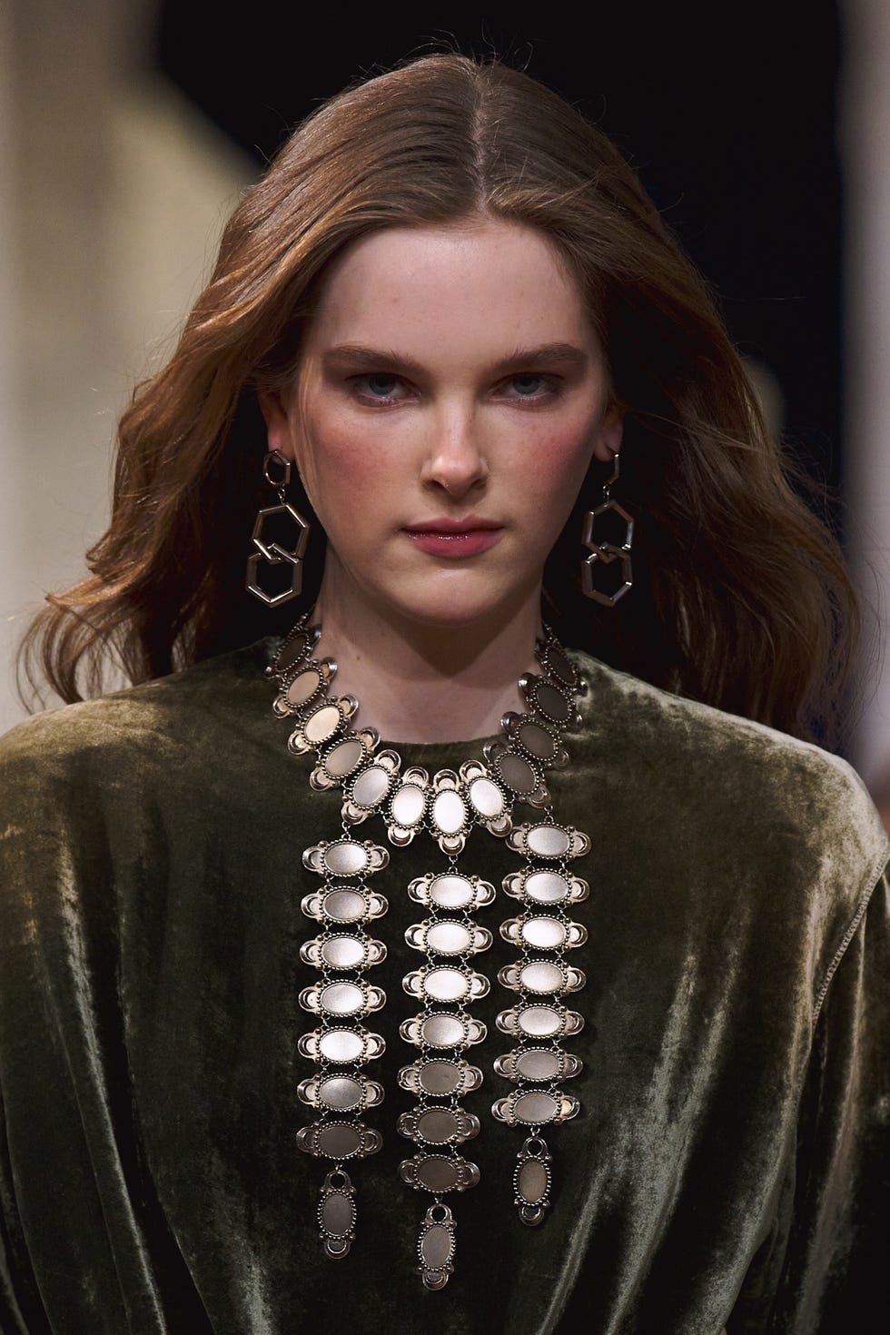 jewelry and fashion display featuring a model in a velvet garment