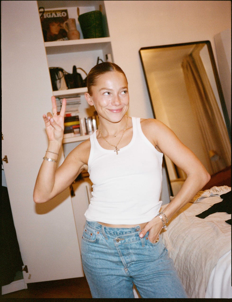 individual posing with a peace sign in a casual outfit