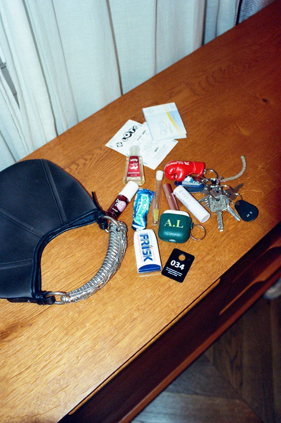 contents of a handbag displayed on a wooden table