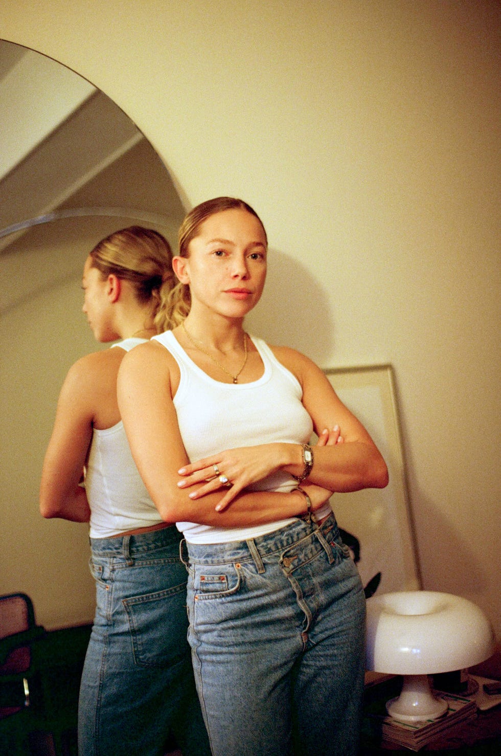 person standing with arms crossed in front of a mirror