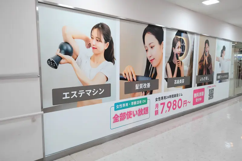「京王ストア高尾店」2階に2006年4月7日にオープンする、女性専用24時間美容サロン「HITORI WELLNESS高尾店」壁面