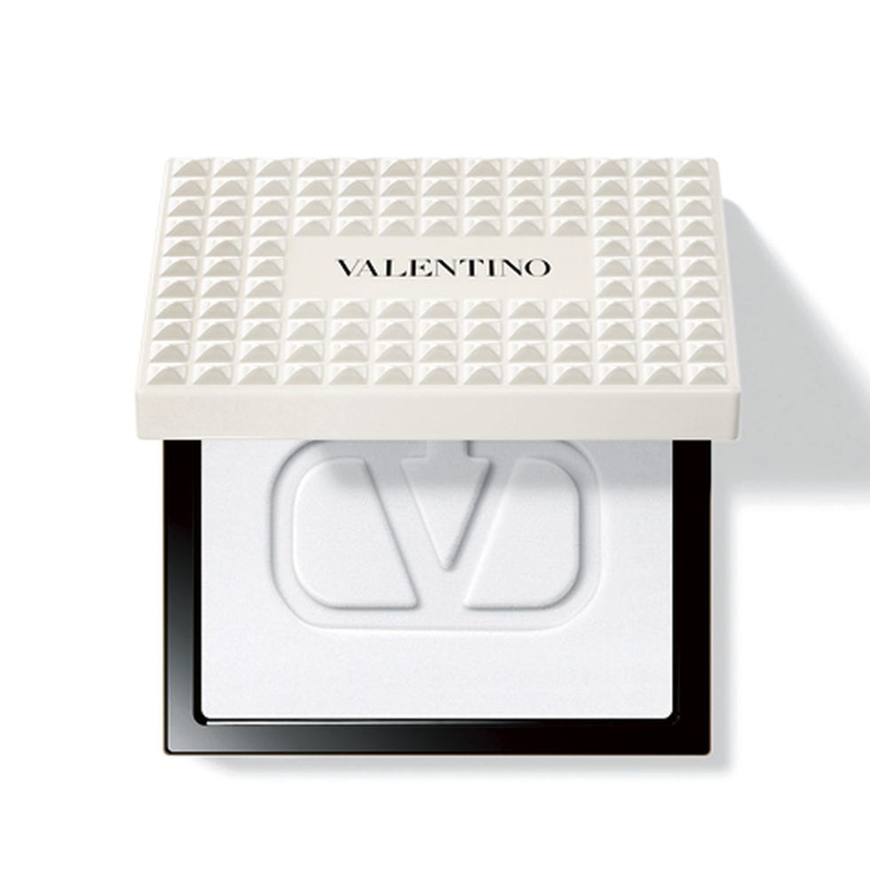 compact makeup product featuring a textured lid and logo