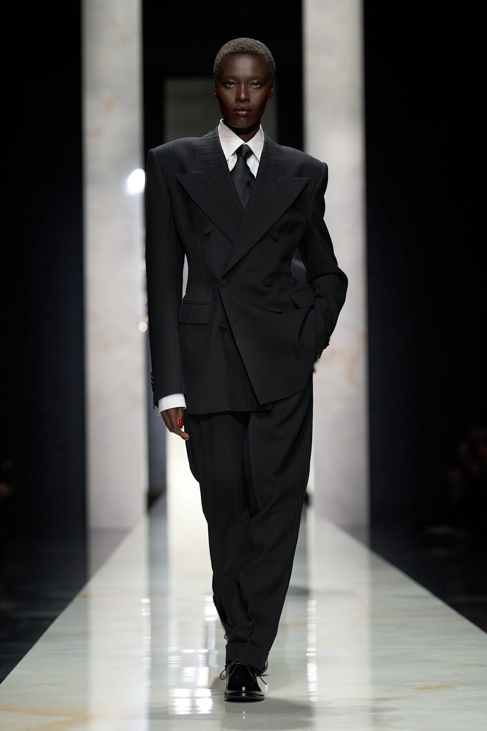 fashion model walking down a runway in a tailored suit