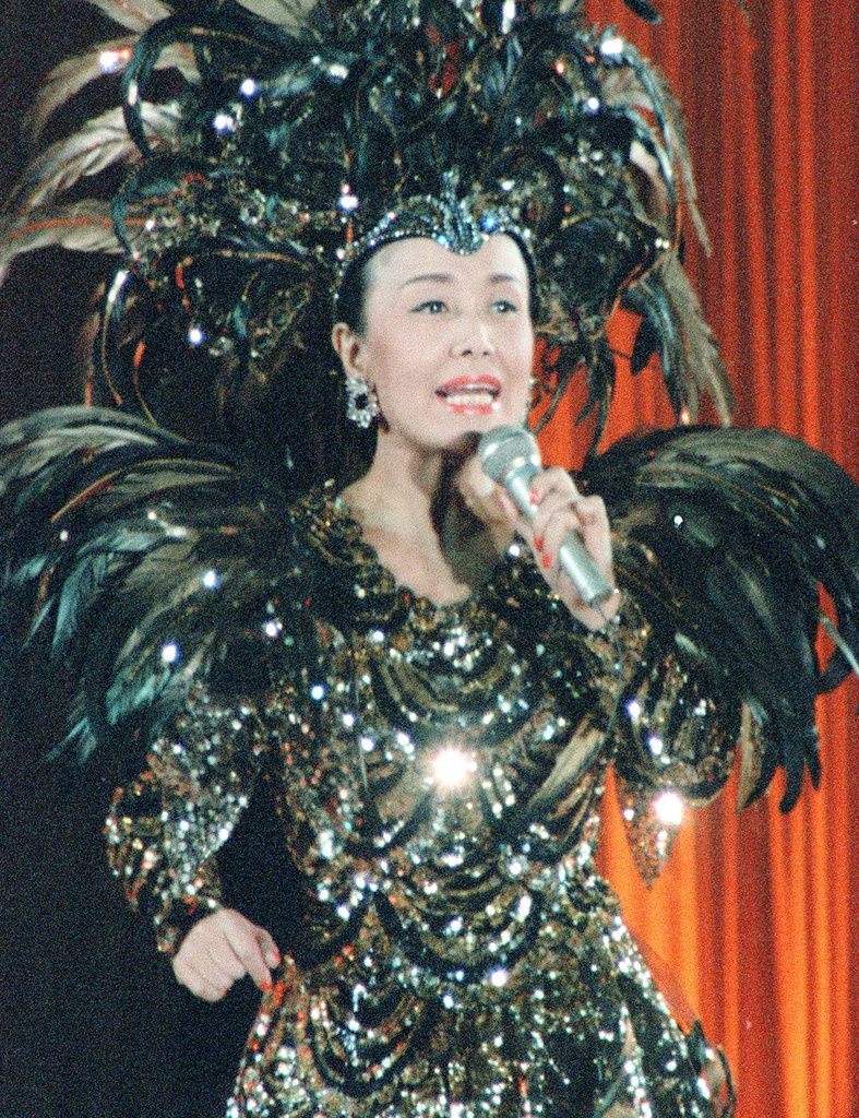 森英恵さんデザインの不死鳥を思わせる衣装で熱唱する美空ひばりさん＝1988年4月、東京都文京区の東京ドーム（共同）