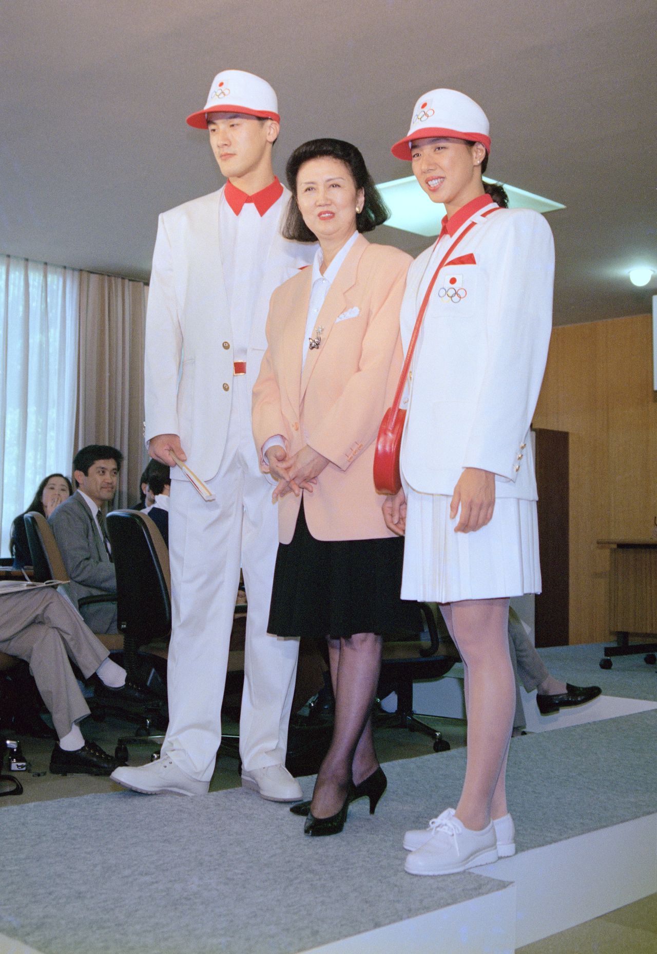 バルセロナ五輪日本選手団の公式ユニホームを披露する森英恵さん（中央）。モデルはバレーボールの中垣内祐一選手（左）とシンクロナイズドスイミングの小谷実可子選手＝1992年、東京・渋谷の岸記念体育会館（時事）