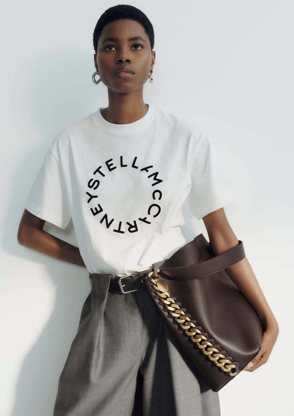 model showcasing a stylish outfit with a logo tshirt and a handbag