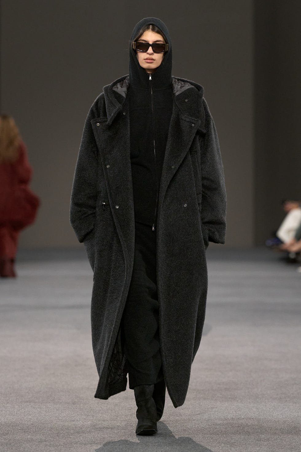 runway model wearing a dark oversized coat