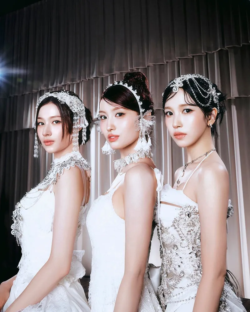 3人の女性が白いドレスと装飾品を身につけてポーズをとっている写真