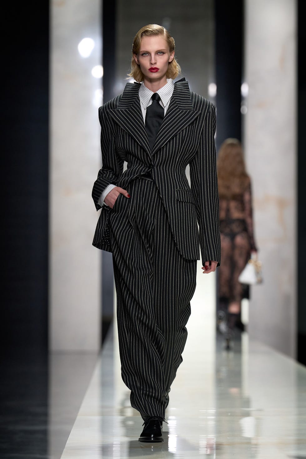 fashion model on runway wearing a pinstripe suit