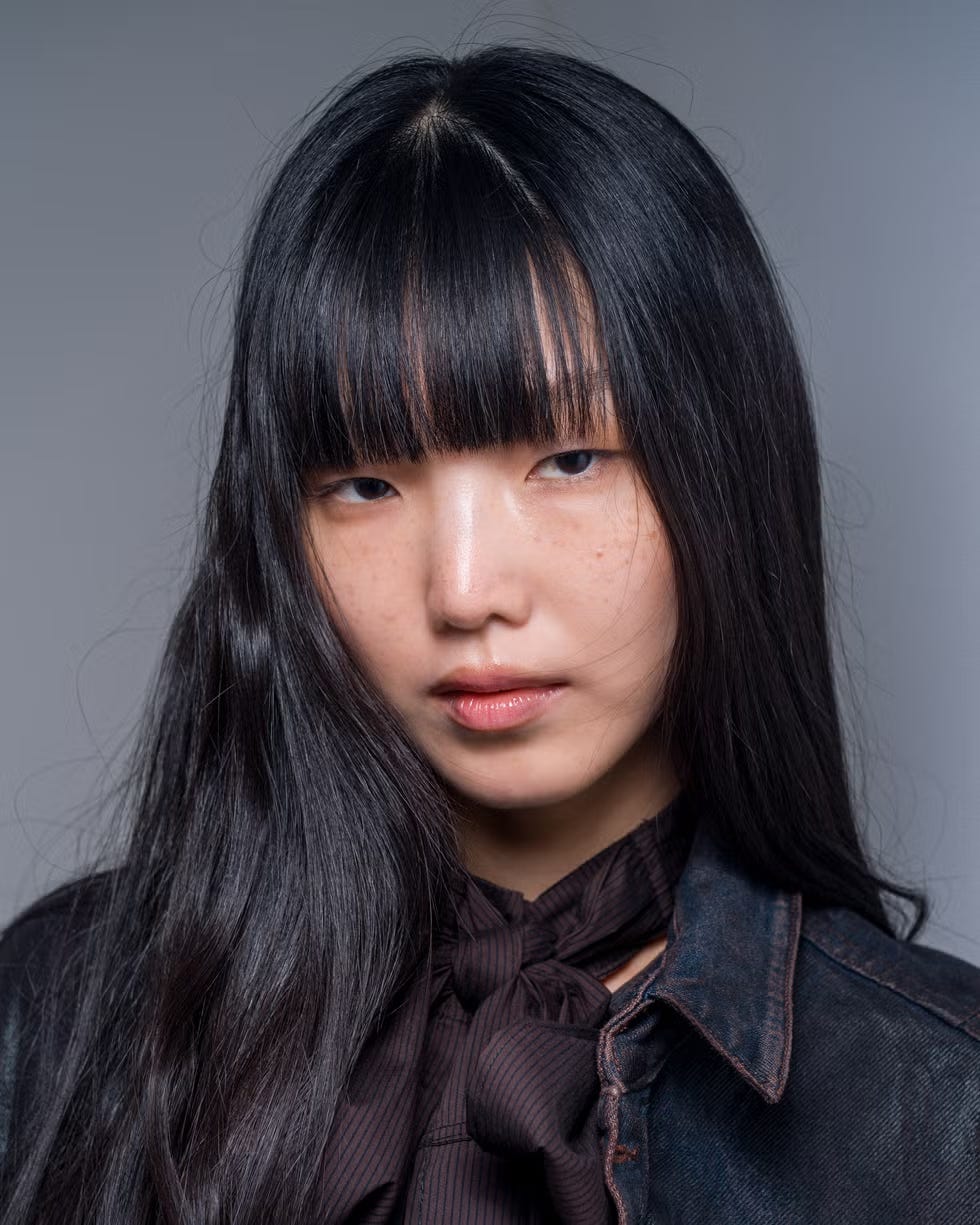 portrait featuring a person with dark hair and a tied neck accessory portrait featuring a person with dark hair and a tied neck accessory