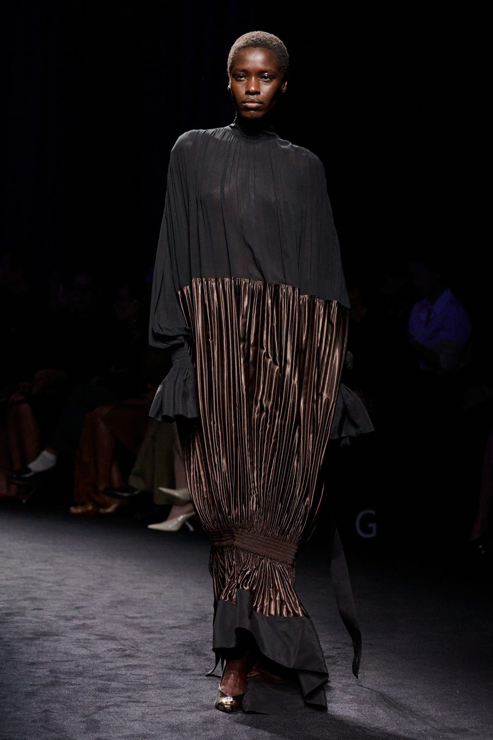 model walking the runway in a dramatic fashion garment