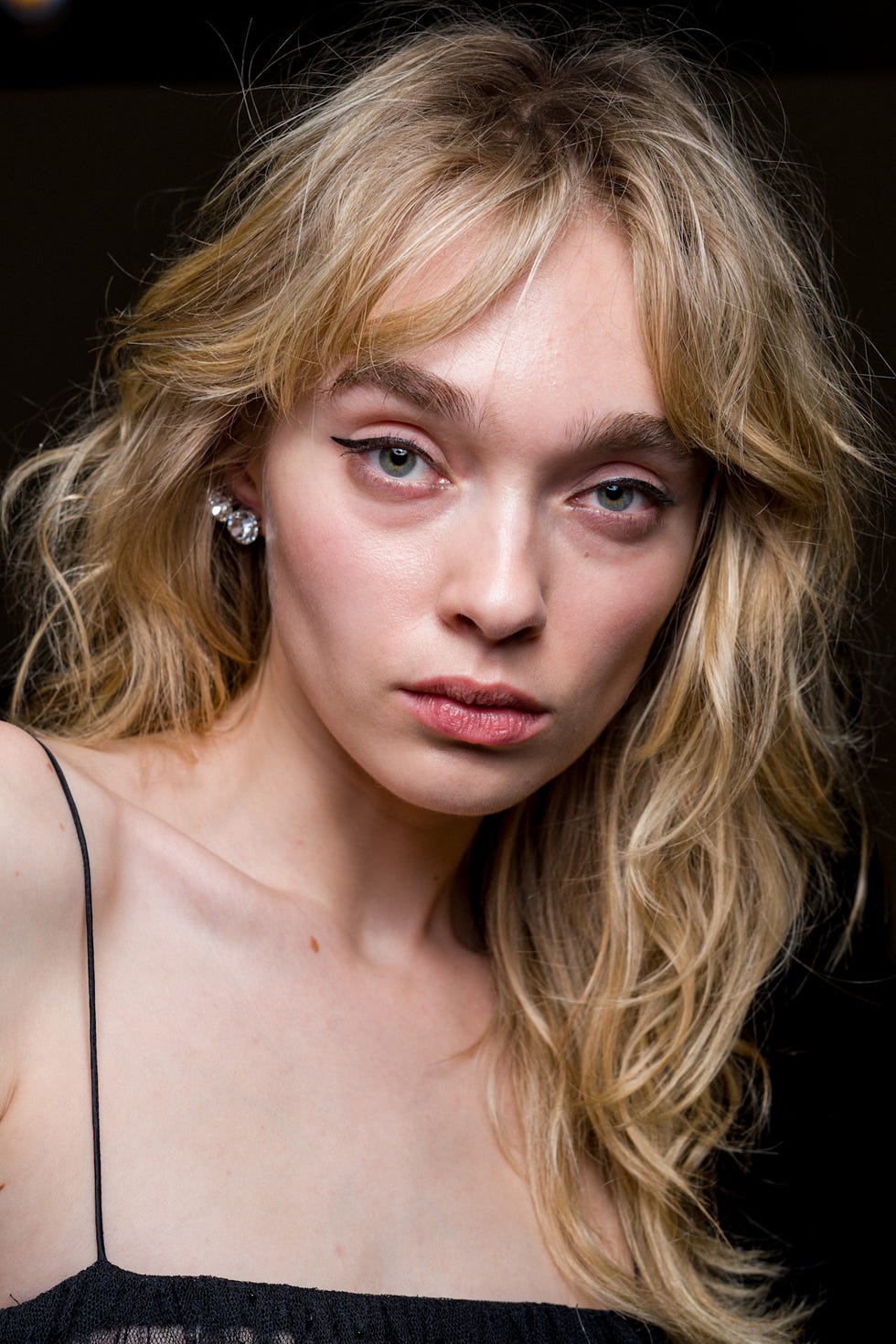 closeup portrait of a person with long wavy blonde hair and large earrings facial features obscured closeup portrait of a person with long wavy blonde hair and large earrings facial features obscured