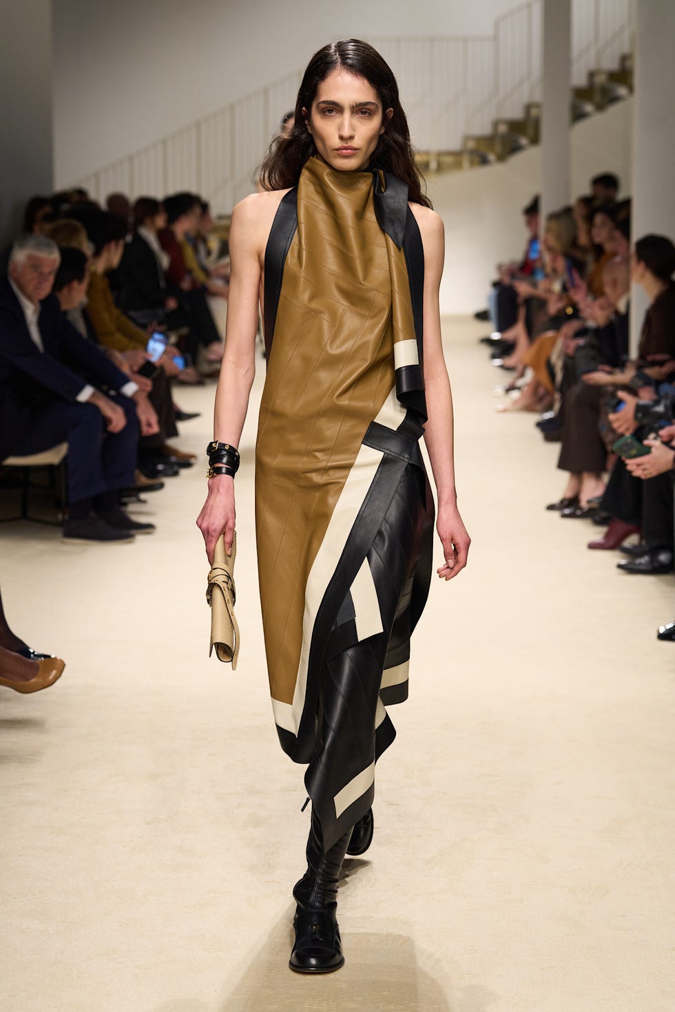 fashion model walking down the runway wearing a unique leather dress