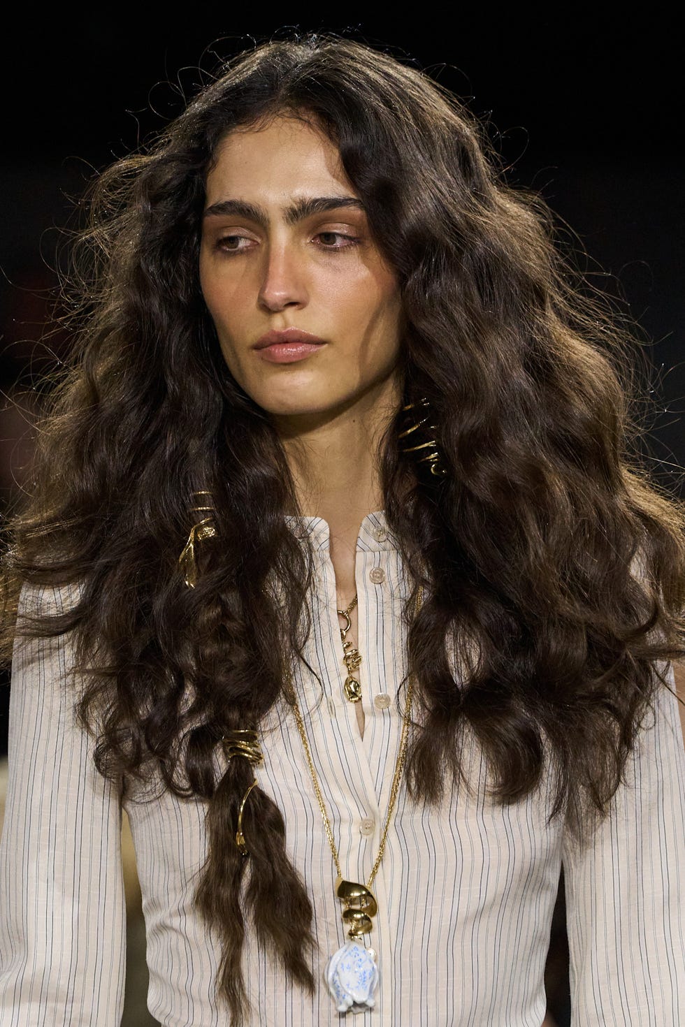 model with wavy hair and a striped shirt adorned with jewelry model with wavy hair and a striped shirt adorned with jewelry