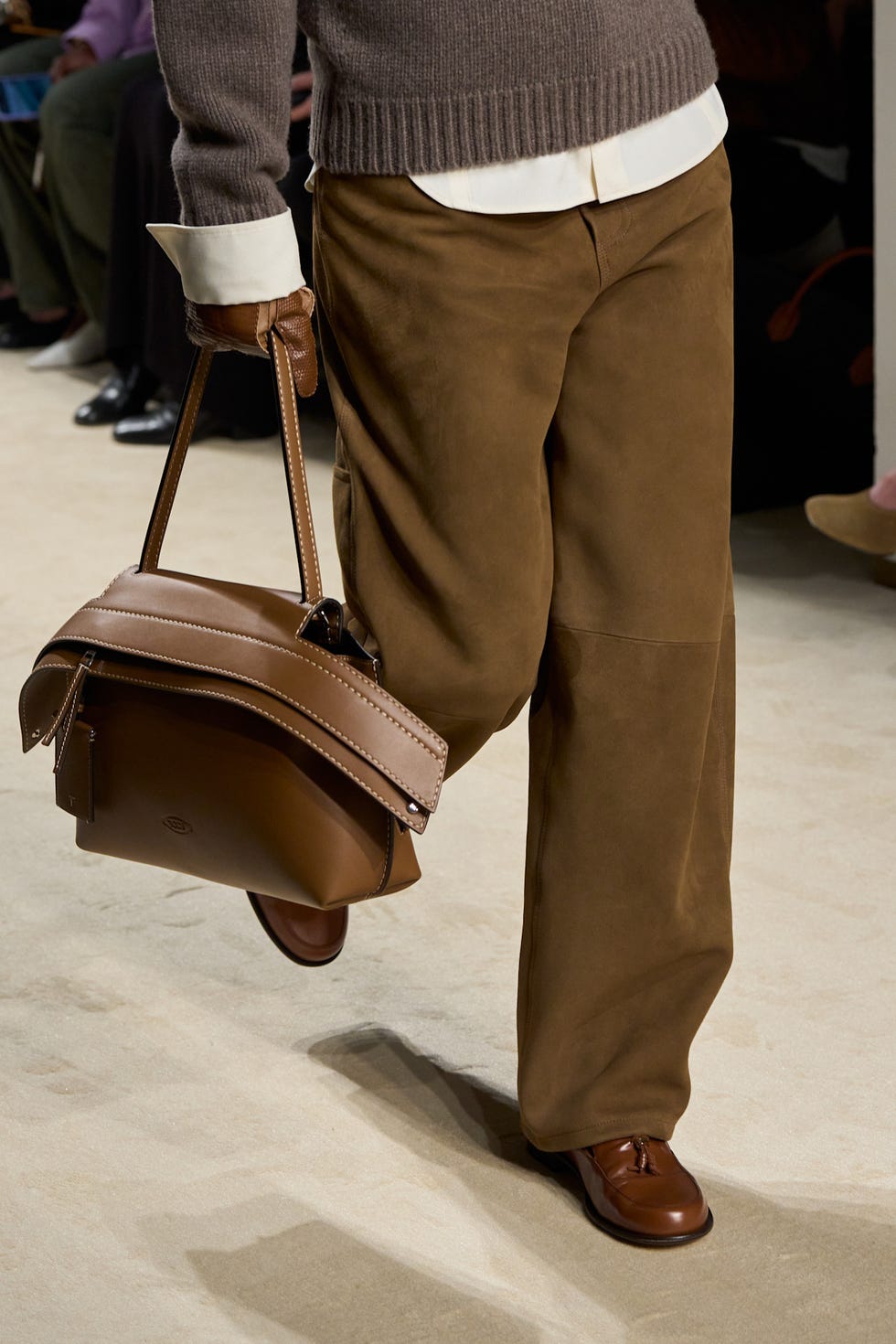 a model showcasing a fashion outfit with a handbag